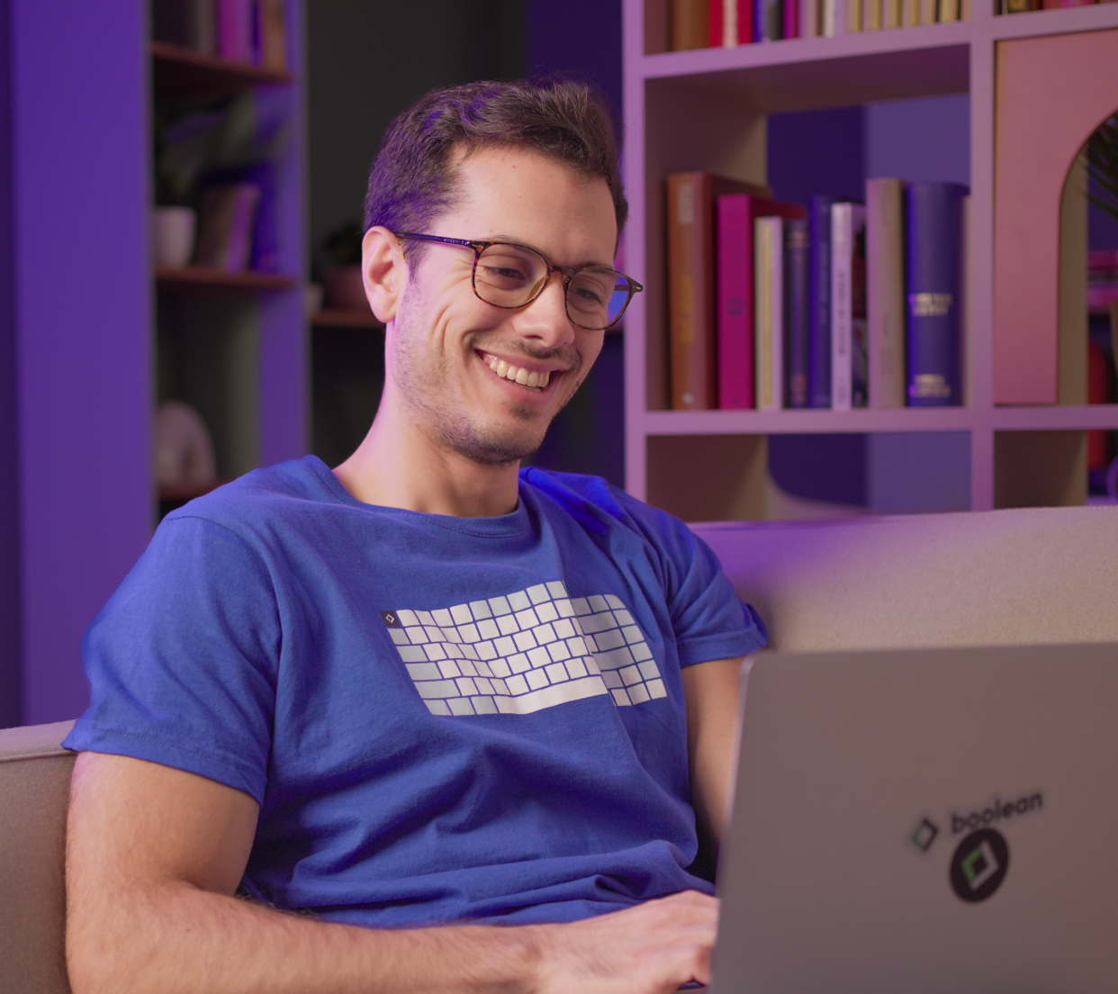 Studente segue una diretta del Summer of AI dal divano con cuffie e laptop